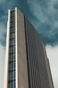white high-rise building under gray clouds thumbnail