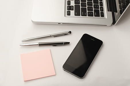 iPhone 6 beside MacBook on white surface thumbnail