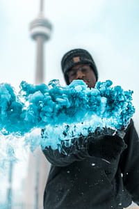 man holding blue smoke bomb thumbnail