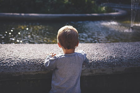 boy standing near outdoor fountain thumbnail