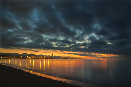 calm body of water against orange sky thumbnail