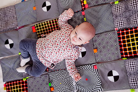 baby lying on gray mat thumbnail