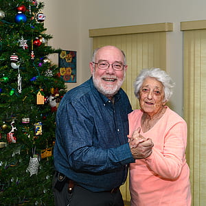 old couple standing beside pre-lit tree thumbnail