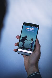 person holding silver LG smartphone thumbnail