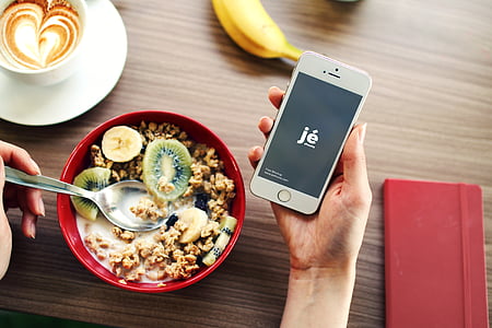 person holding iPhone 5s displaying JE thumbnail