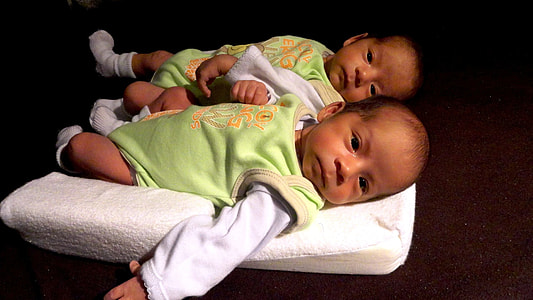 two babies lying on cushion thumbnail