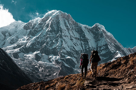 two person hiking on mountain under blue sky thumbnail