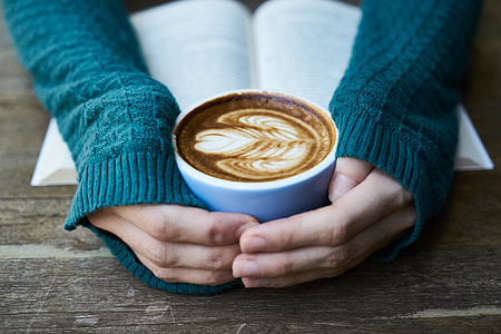 person holding blue ceramic coffee cup thumbnail