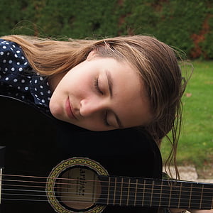 woman sleeping on top of her black guitar thumbnail