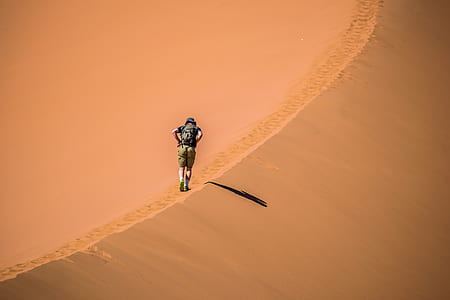man walking in desert during daytime thumbnail