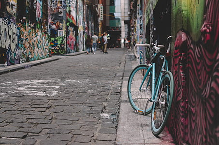 teal fixie bike leaned on wall thumbnail