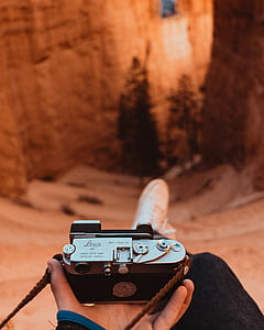 person holding gray and black camera thumbnail