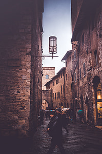 people walking between concrete buildings during daytime thumbnail