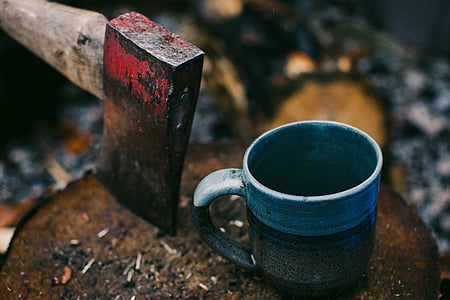 blue ceramic coffee mug beside axe thumbnail