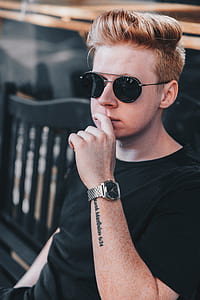 man wearing black shirt sitting on black bench thumbnail
