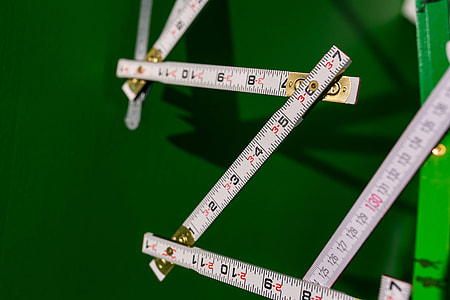 Extandable wooden ruler on a green background thumbnail