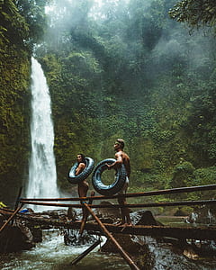 man and woman holding floater near waterfalls thumbnail