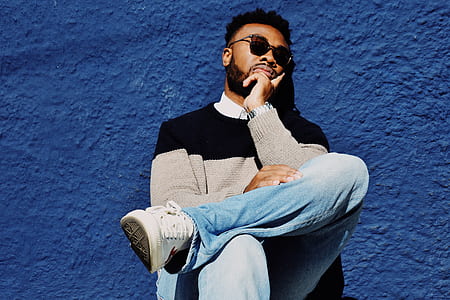 man leaning on wall with cross legs thumbnail