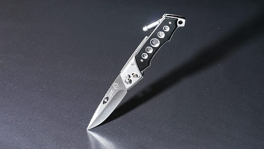 gray and black folding knife on gray surface thumbnail