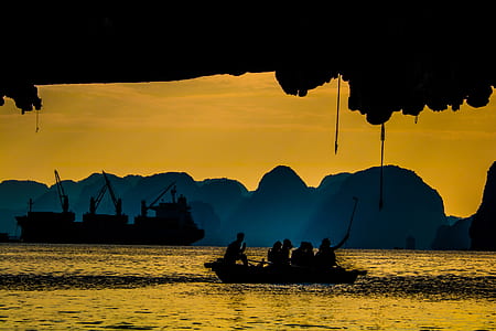 people on boat beside rock formation thumbnail