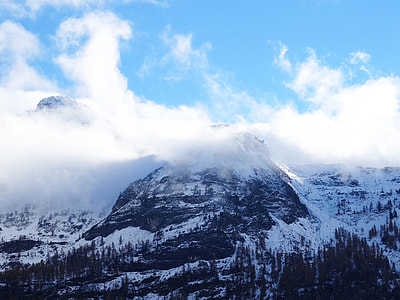 snow coated black mountains photo during daytime thumbnail