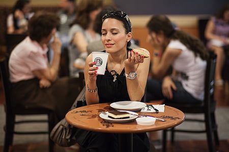 woman wearing black sleeveless dress while sitting on chair thumbnail