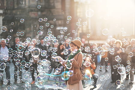 woman standing surrounded by bubbles during daytime thumbnail