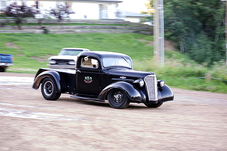 classic black vehicle on road during daytime thumbnail