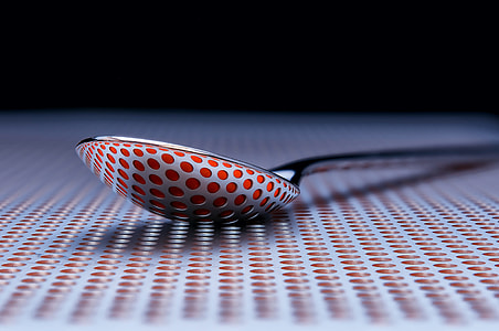 close up photo of stainless steel spoon on white and red dotted surface thumbnail