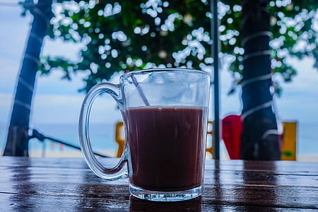 Clear Glass Mug With Beverage on Brown Wooden Table thumbnail