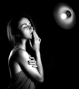 grayscale photo of woman in front of light bulb thumbnail
