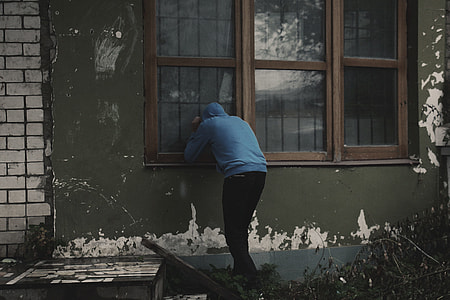person wearing blue hoodie looking at window thumbnail