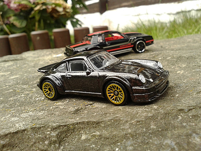 two black and red toy cars on rock thumbnail