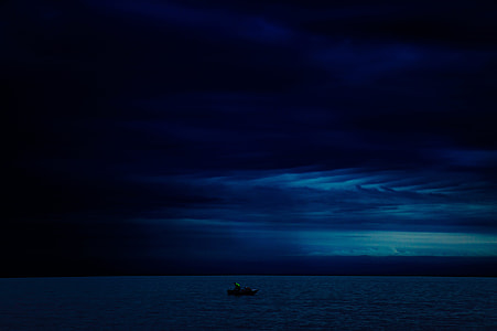 silhouette of a boat on body of water during nighttime thumbnail