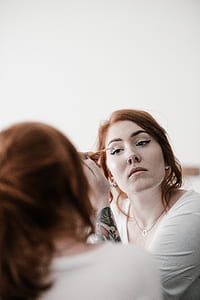 woman putting liquid eyeliner photograph thumbnail