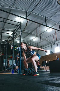 Woman Holding Adjustable Dumbbell With Her Right Hand at Gym thumbnail