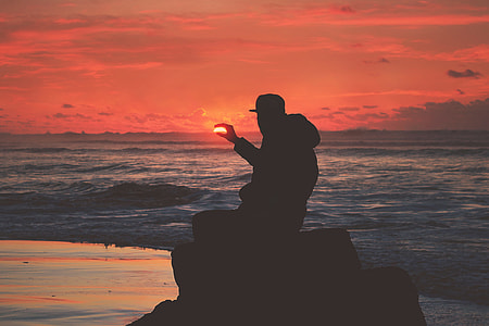 Silhouette of a man on the coast at sunset thumbnail