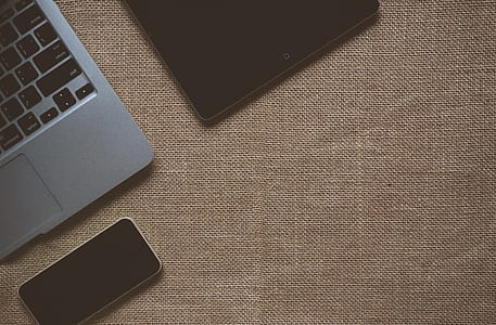 Black Ipad Near Macbook on Brown Textile thumbnail