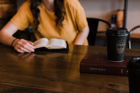 woman wearing yellow shirt sitting while reading book thumbnail