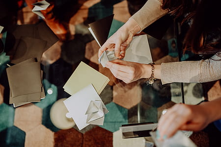 Women folding sheet of paper while making origami thumbnail