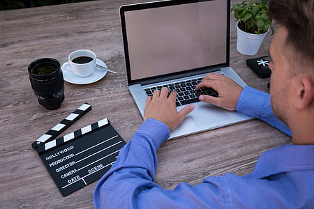 person sitting beside table while using laptop thumbnail