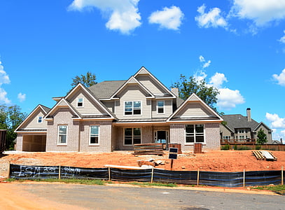 brown concrete house under blue and white skies thumbnail