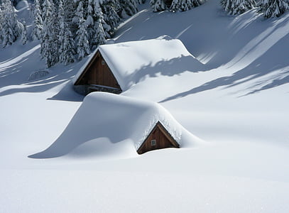 two brown huts covered in snow thumbnail