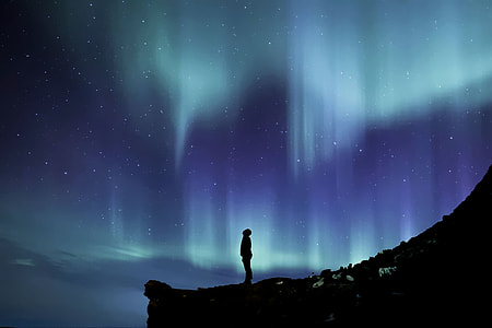 person standing in mountain viewing Aurora thumbnail