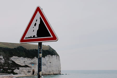 triangular signage on beach during daytime thumbnail