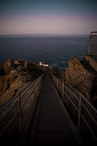 pathway downwards leading to house beside body of water thumbnail