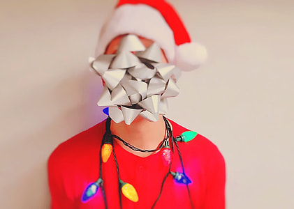 selective focus photography of gray kaleido lamp in front of man in red with Santa hat and strip light rolled on his head thumbnail
