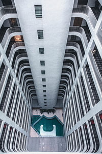 aerial photo of swimming pool between concrete building at daytime thumbnail