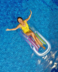 woman wearing yellow monokini on inflatable boat on pool thumbnail