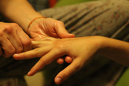 person massaging the hand of woman thumbnail